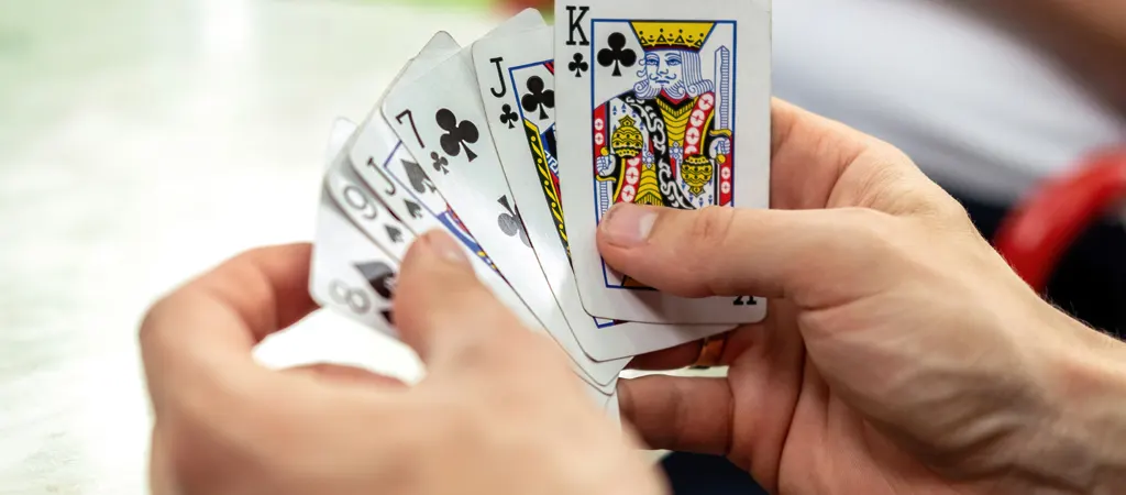 R&ouml;mi szab&aacute;lyok &uacute;tmutat&oacute;, j&aacute;t&eacute;kos k&eacute;zben tartott k&aacute;rtyalapokkal, j&aacute;t&eacute;k k&ouml;zbeni pillanat