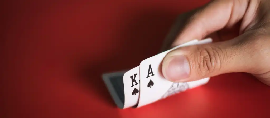 Blackjack szab&aacute;lyok &eacute;s d&ouml;nt&eacute;si lehetős&eacute;gek, j&aacute;t&eacute;kos kez&eacute;ben &aacute;sz &eacute;s kir&aacute;ly k&aacute;rtya v&ouml;r&ouml;s h&aacute;tt&eacute;ren