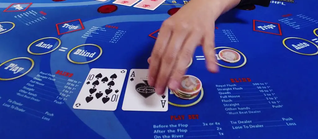 Ultimate Texas Holdem Poker j&aacute;t&eacute;kmenet kaszin&oacute;asztalon, j&aacute;t&eacute;kos z&aacute;rt lapokkal &eacute;s zsetonokkal t&eacute;teket helyezve