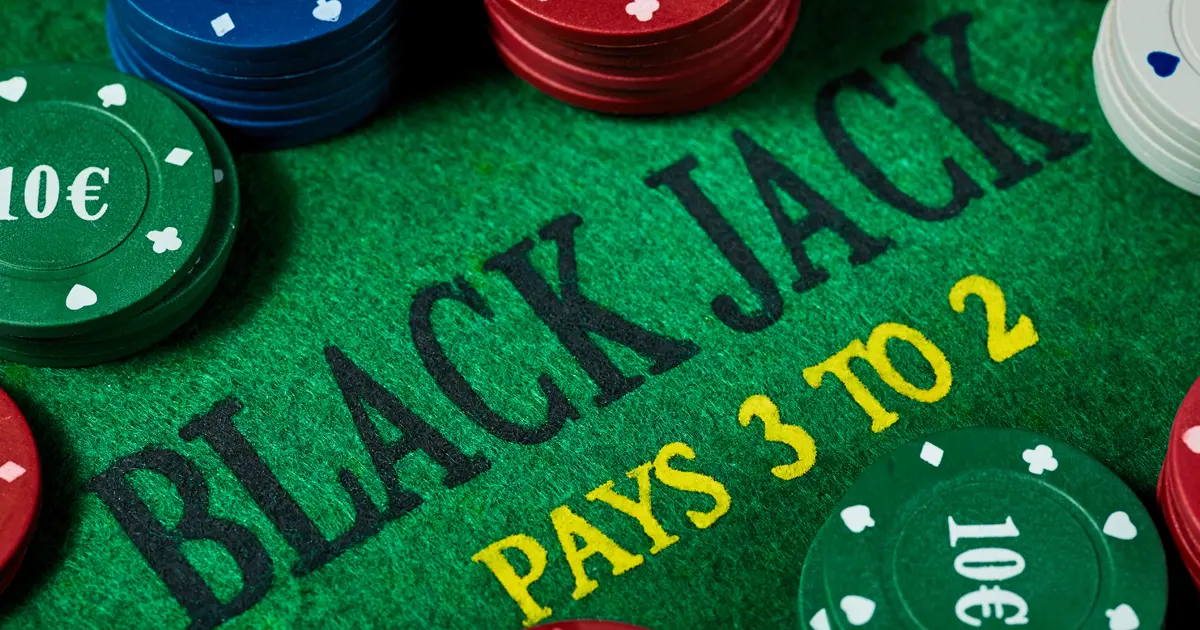 Black jack asztal zsetonokkal és felirattal, amely szemléletesen mutatja be, mit takar a black jack stratégia jelentése a gyakorlatban