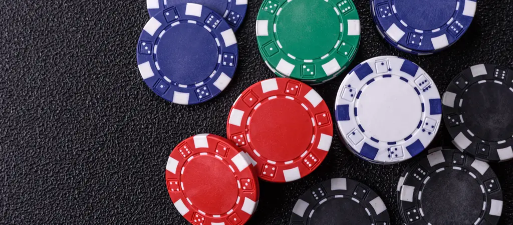 K&uuml;l&ouml;nb&ouml;ző sz&iacute;nű poker zsetonok k&ouml;zelről, amelyek seg&iacute;tenek meg&eacute;rteni a p&oacute;ker zseton sz&iacute;nek &eacute;s &eacute;rt&eacute;kek logik&aacute;j&aacute;t j&aacute;t&eacute;k k&ouml;zben