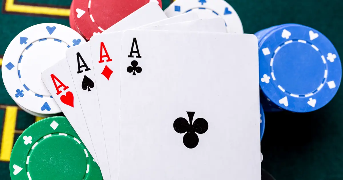 Ász lapok és különböző színű poker zsetonok egy asztalon, amelyek jól szemléltetik a póker zseton színek jelentését es értékek közötti különbségeket