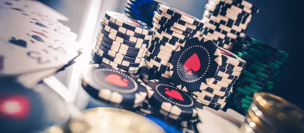 Kaszin&oacute; zsetonok &eacute;s j&aacute;t&eacute;kk&aacute;rty&aacute;k k&ouml;zeli r&eacute;szlete, amely a martingale strat&eacute;gia jelent&eacute;s&eacute;t &eacute;s a vesztes&eacute;gek visszanyer&eacute;s&eacute;re &eacute;p&uuml;lő fogad&aacute;si rendszer alapelveit illusztr&aacute;lja