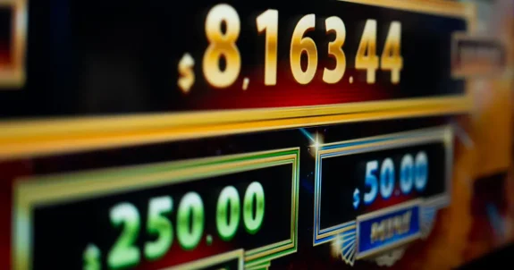 Nyerőgép pénznyeremény kijelzője különböző kifizetési szintekkel és jackpot összegekkel, amely a slot játékok nyerési esélyei és hosszú távú megtérülési arányának működését szemlélteti